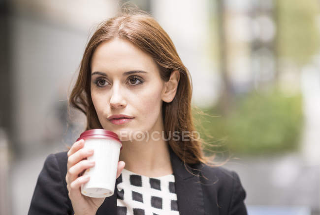 Портрет Жінка тримає одноразові кавові чашки фотографіях хтось дивитися вбік — стокове фото