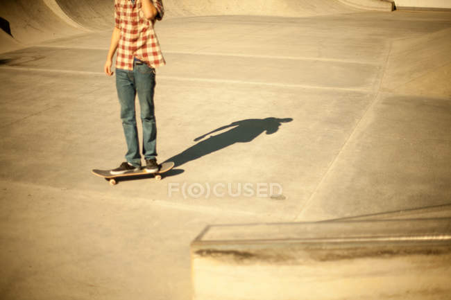 Skateboarder no parque de skate iluminado sol, tiro cortado — Fotografia de Stock