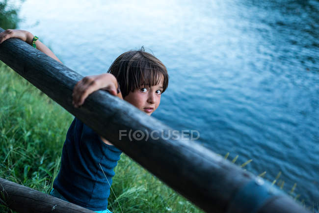 Junge am Fluss blickt Kamera über die Schulter — Stockfoto