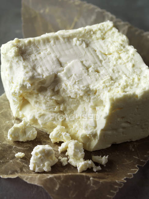 Feta cheese on wrapping paper, close up shot — Stock Photo