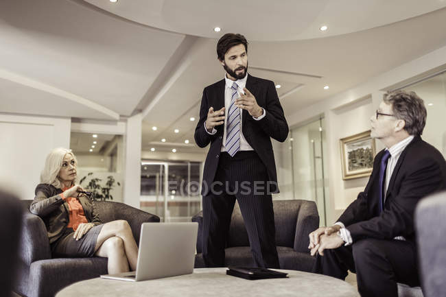 Зрелый бизнесмен объясняет на встрече — стоковое фото