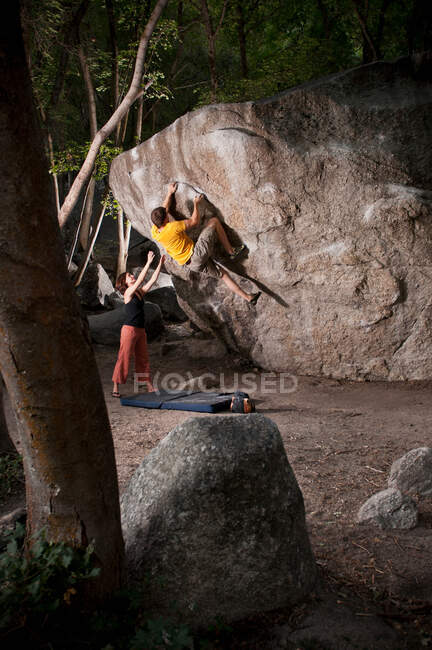 Rock climbers scaling boulder face — Stock Photo