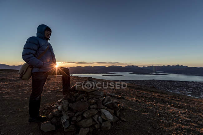 Hombre escalando una cumbre cerca de Tromso en otoño, Ártico Noruega - foto de stock
