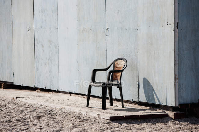 Chair by beach hut wall in sunlight — Stock Photo