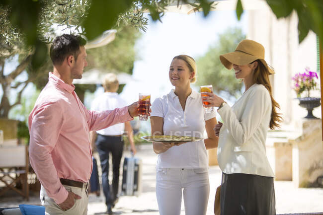 Boutique-Hotelkellnerin begrüßt Paar mit Getränken, Mallorca, Spanien — Stockfoto