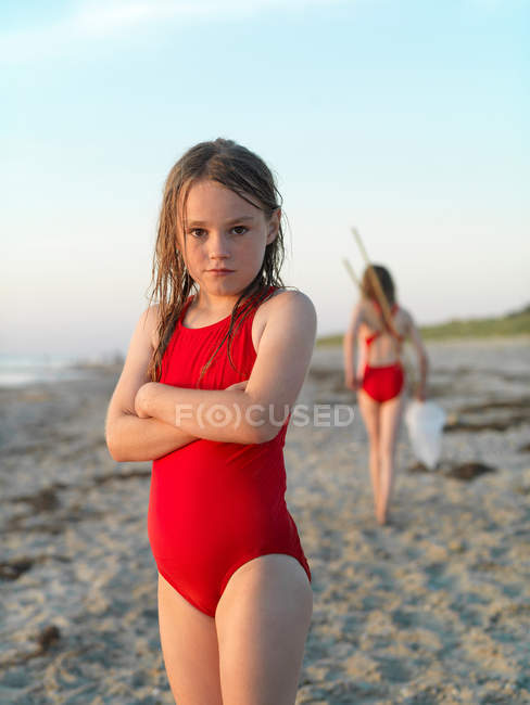 Chica de pie en la playa de arena - foto de stock
