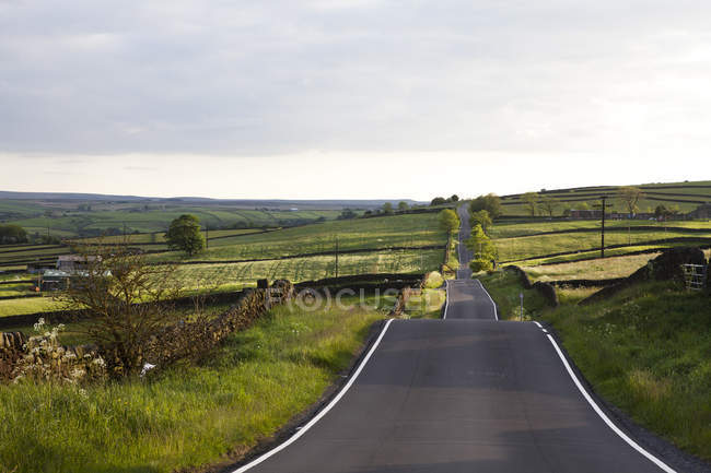 Carretera pavimentada en paisaje rural - foto de stock