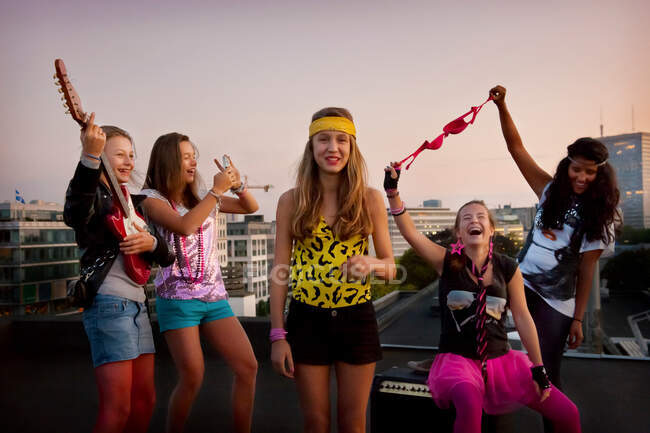 Teenage girls playing music on roof — Stock Photo