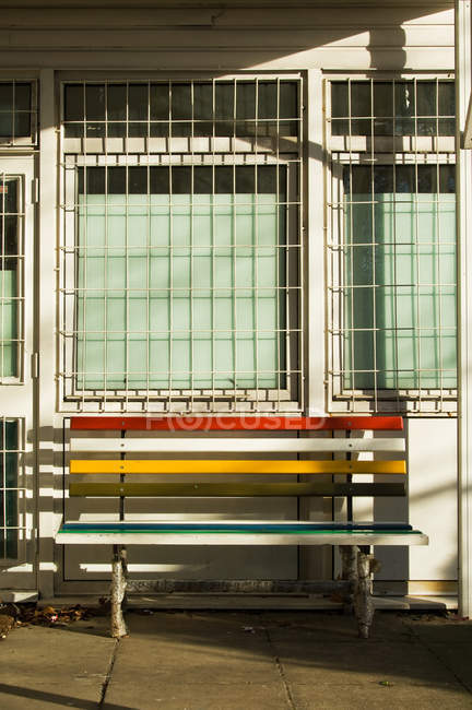 Bank vor dem Gebäude im hellen Sonnenlicht — Stockfoto