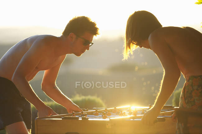 Dois amigos do sexo masculino jogando futebol de mesa, ao ar livre — Fotografia de Stock