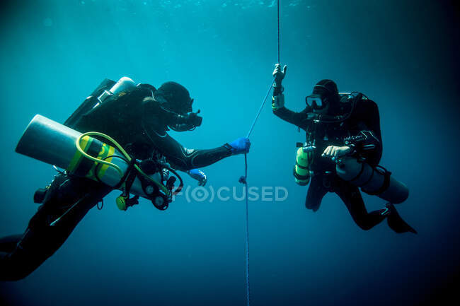Підводний вид двох технічних водолазів, які використовують пристрої для рециркуляції, щоб знайти корабельну аварію, Ломбок, Індонезія. — стокове фото