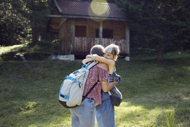 Two female friends hugging in forest glade, Sattelbergalm, Tyrol, Austria — Stock Photo