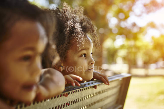 Deux jeunes sœurs regardant sur le banc — Photo de stock