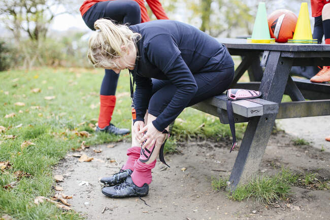 Female soccer player putting on shin pad — Stock Photo