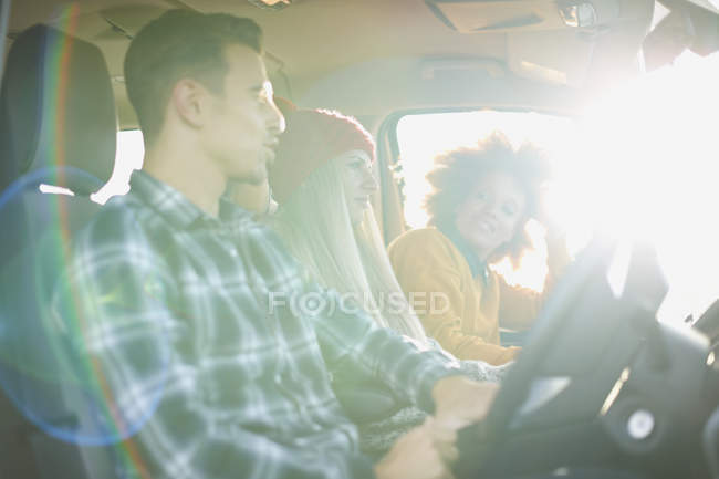 Tre giovani amici adulti che guidano in auto illuminata dal sole — Foto stock