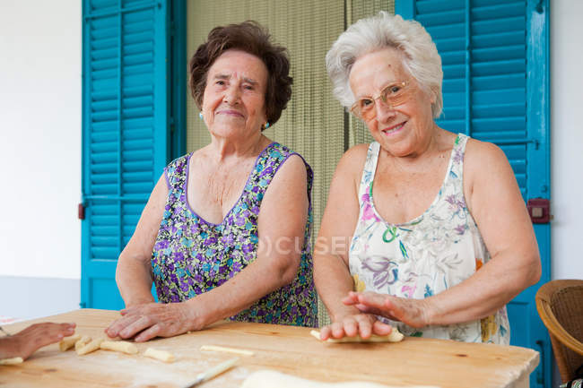 Літні жінки роблять макарони разом — стокове фото