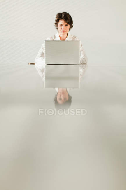 Mujer de negocios reflejado en la tabla - foto de stock