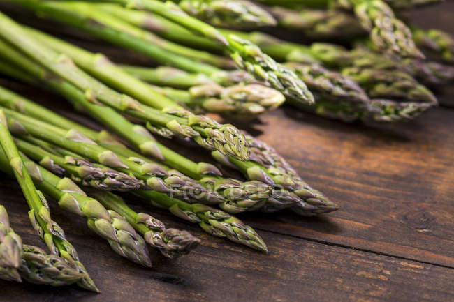Fresh green asparagus on wooden table — Stock Photo