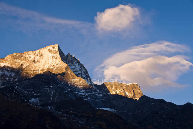 Schneebedeckter Berggipfel im Sonnenlicht mit blauem Himmel — Stockfoto