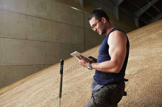 Homem usando computador tablet em grão — Fotografia de Stock