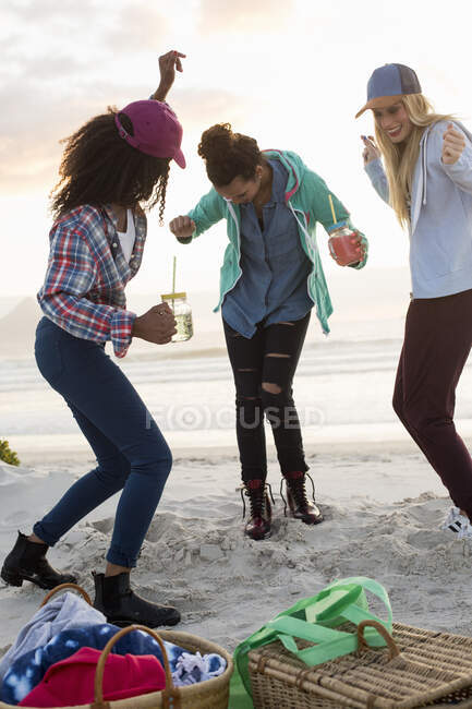 Троє молодих жінок танцюють на пляжному пікніку (Кейптаун, Західна Кейптаун, ПАР). — стокове фото