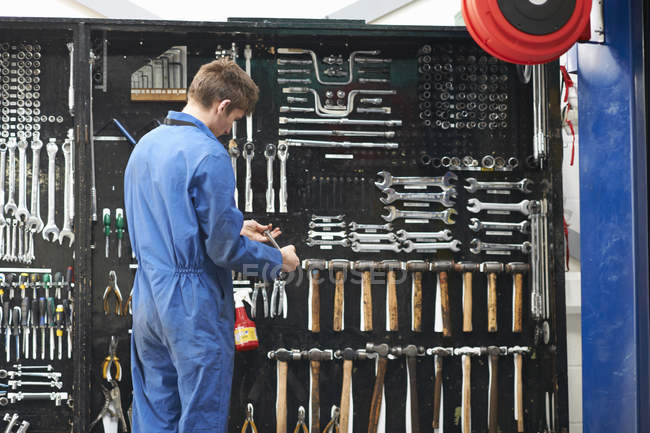 Студент коледжу механіки вибирає ключ від ремонту комплекту інструментів гаража — стокове фото