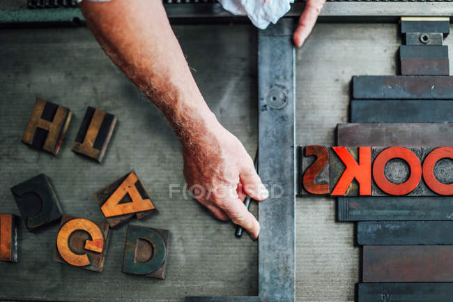 Detalhe da mão usando a máquina de tipografia na oficina de artes do livro, vista aérea — Fotografia de Stock