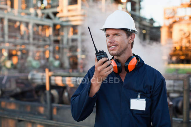 Trabalhador usando walkie talkie no local — Fotografia de Stock