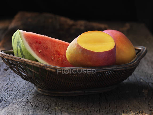Свіжі манго та кавун у плетеному кошику — стокове фото