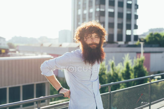 Portrait of young male hipster with red hair and beard on roof terrace — Stock Photo