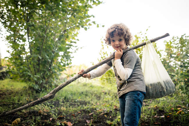 Портрет мальчика с шестом и каштанами в виноградниках — стоковое фото