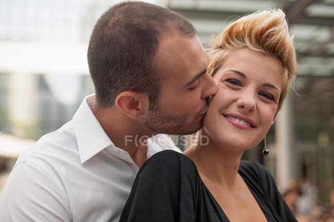 Усміхнена пара цілується на відкритому повітрі — стокове фото