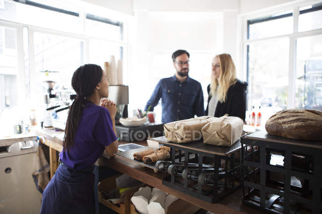 Waitress serving couple at cafe counter — Stock Photo