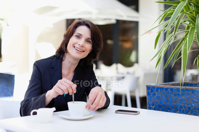 Empresaria tomando café en la cafetería - foto de stock