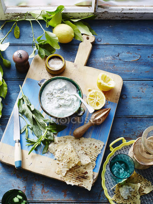 Bowls of tzatziki with flatbread on table — Stock Photo