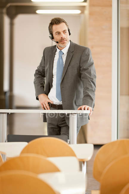 Businessman wearing headset at podium — Stock Photo