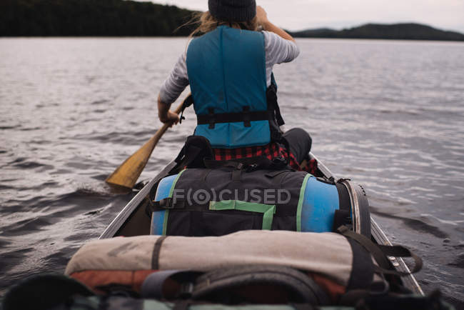 Mulher canoagem no lago, vista traseira — Fotografia de Stock