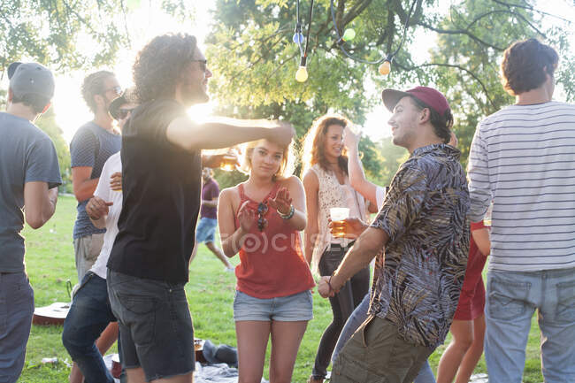 Amis adultes dansant au parc fête au coucher du soleil — Photo de stock