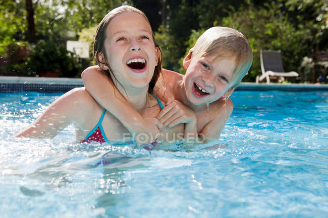 Menina e menino na piscina — Fotografia de Stock