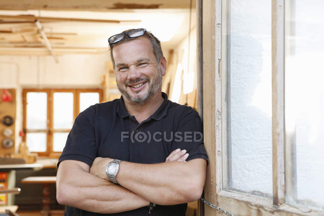 Portrait of man with crossed hands in workshop — Stock Photo