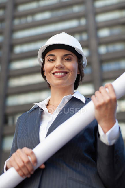 Porträt einer Geschäftsfrau mit Bauplänen im Freien — Stockfoto