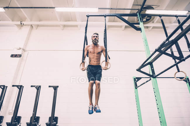 Treinamento de treinador cruzado masculino jovem em anéis de ginástica — Fotografia de Stock