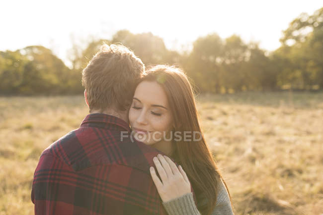 Junges Paar in ländlicher Umgebung, umarmt — Stockfoto