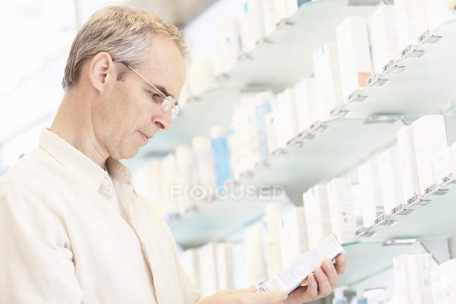Apotheker untersucht Schachtel mit Pillen — Stockfoto