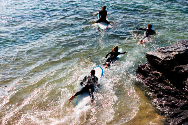 Quattro persone su tavole da surf in acqua — Foto stock