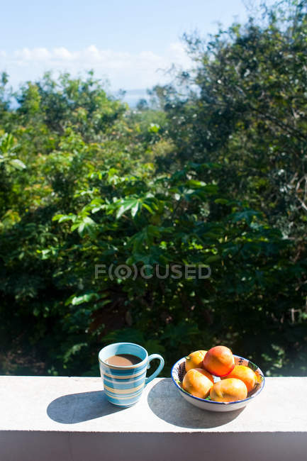 Früchte in Schüssel und Kaffee an der Wand — Stockfoto