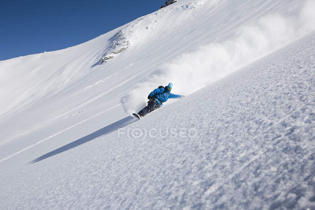 Snowboarder masculin accélérant sur une montagne escarpée, Trient, Alpes suisses, Suisse — Photo de stock