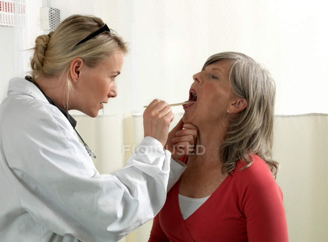 Doctor examining mature woman — Stock Photo