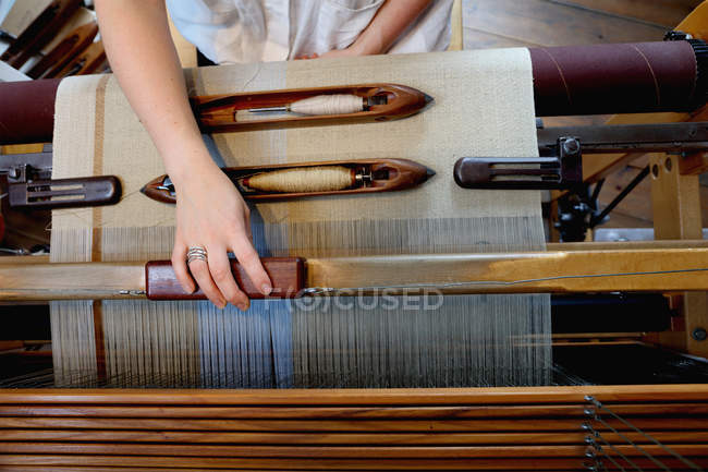 Mains de jeune femme utilisant métier à tisser — Photo de stock