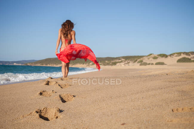 Mujer en la playa llevando sarong, Piscinas, Cerdeña, Italia - foto de stock